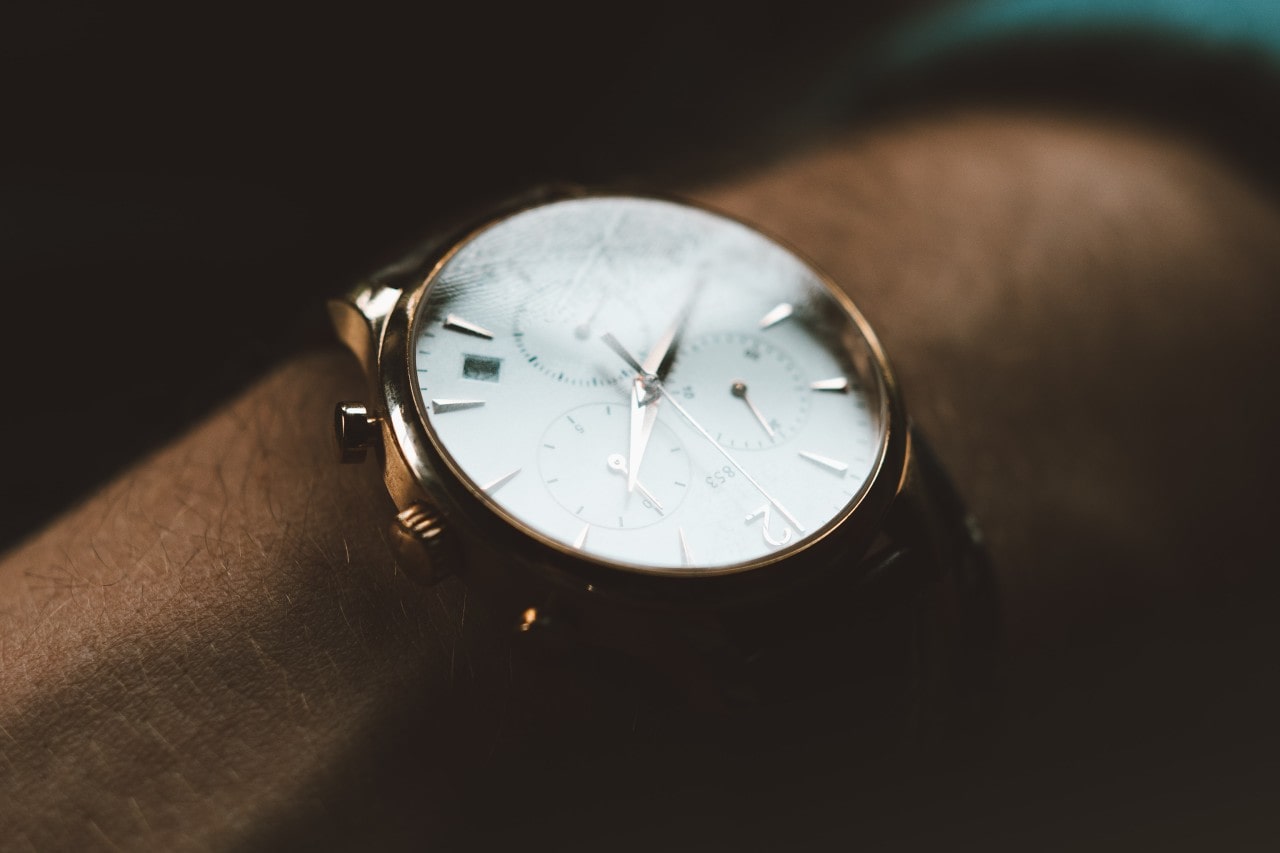 Close up image of a gold and white watch with three subdials