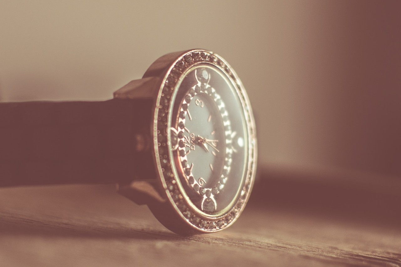 A slightly blurred vision of a watch with black gemstone details and a beam of light falling on its fac