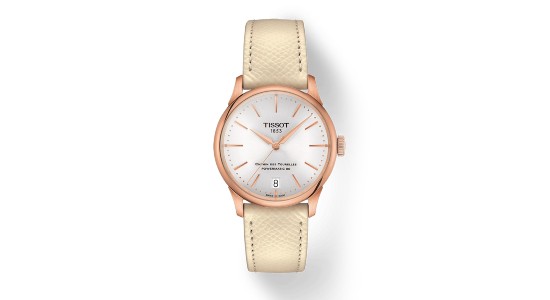 a rose gold Tissot watch with a minimalist dial and a nude strap