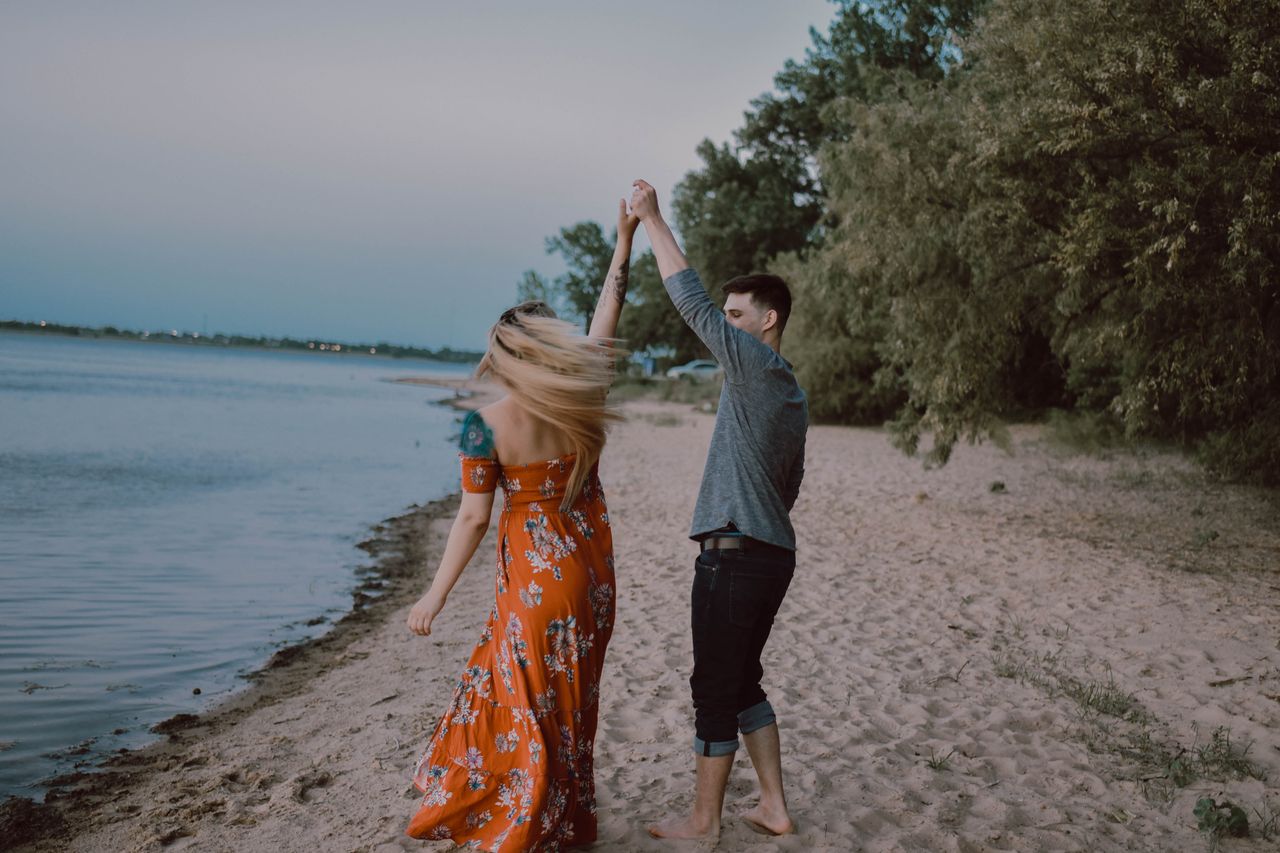 A couple dancing on a private beach with a romantic filter.