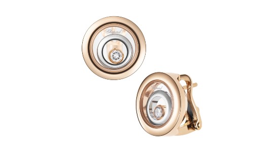 a pair of mixed metal earrings by Chopard featuring a floating diamond