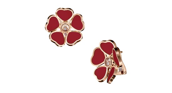 a pair of rose gold stud earrings by Chopard featuring red hearts and a floral silhouette