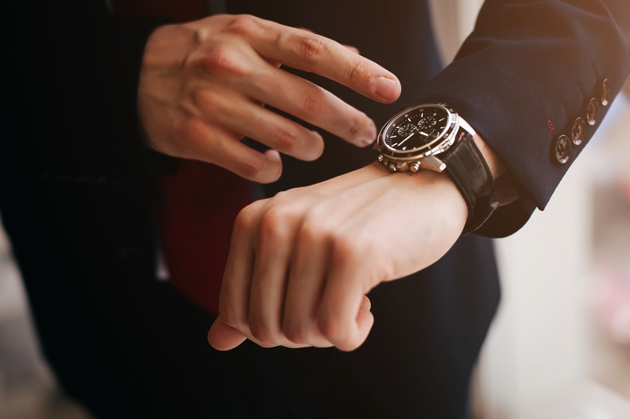 designer watch on hand of man in suit