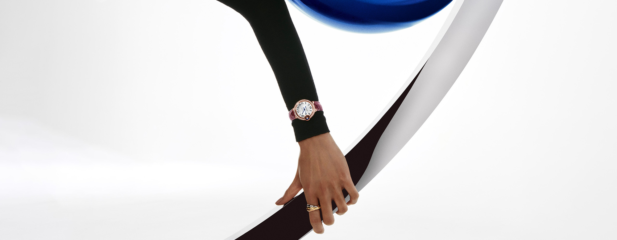 a lady’s outstretched arm wearing a Ballon Bleu de Cartier watch
