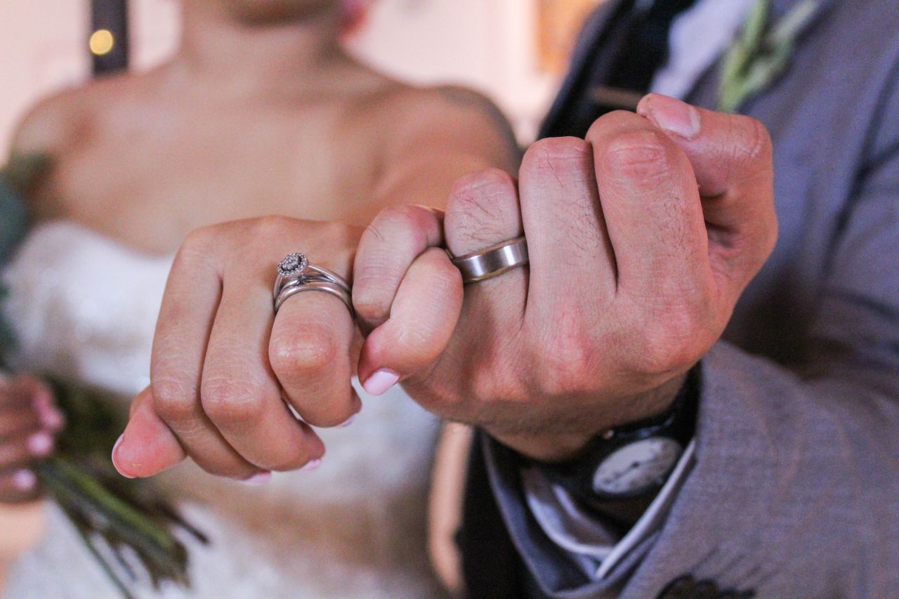 bride and groom’s hands wearing various bridal rings