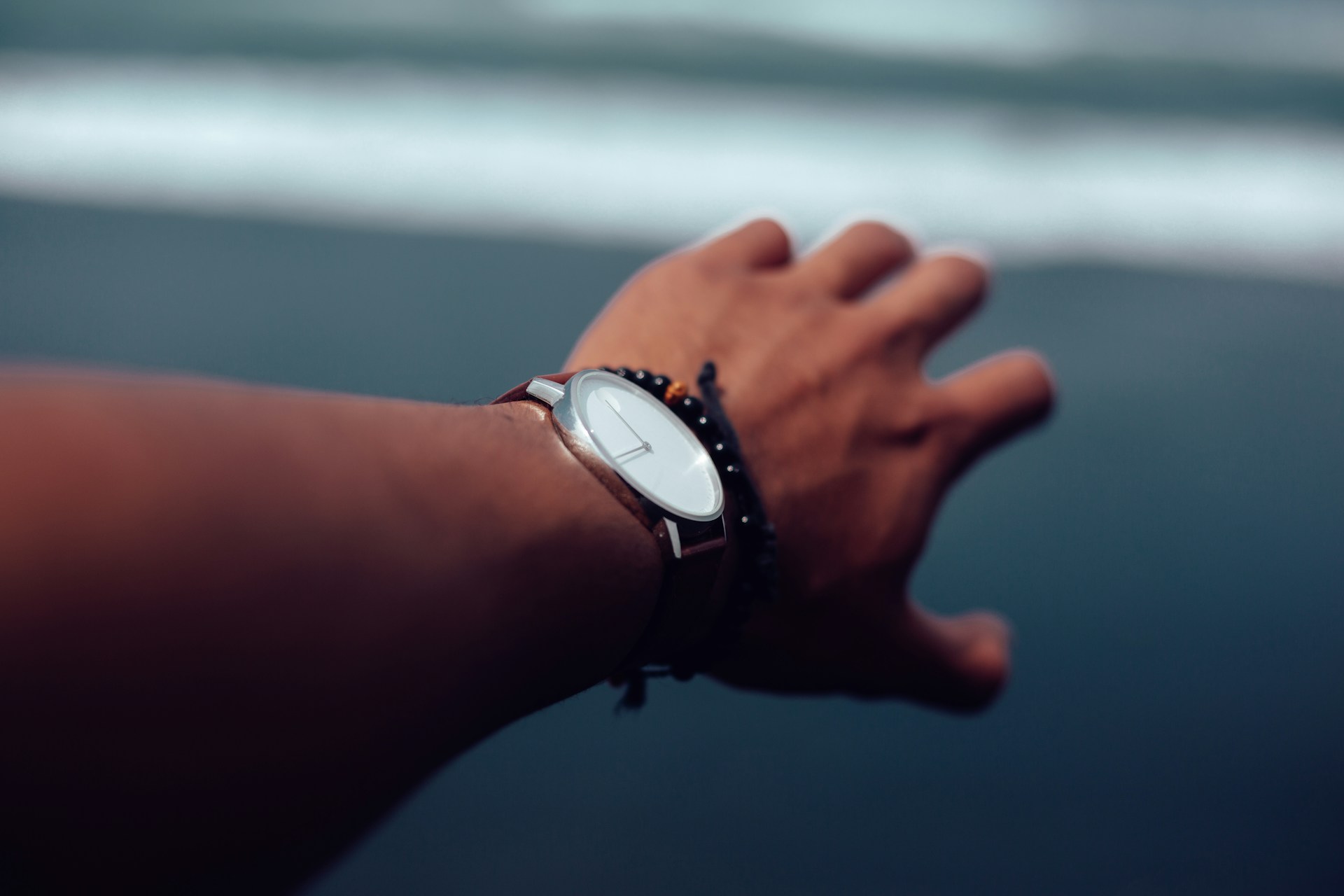 a hand wearing a watch and a bracelet