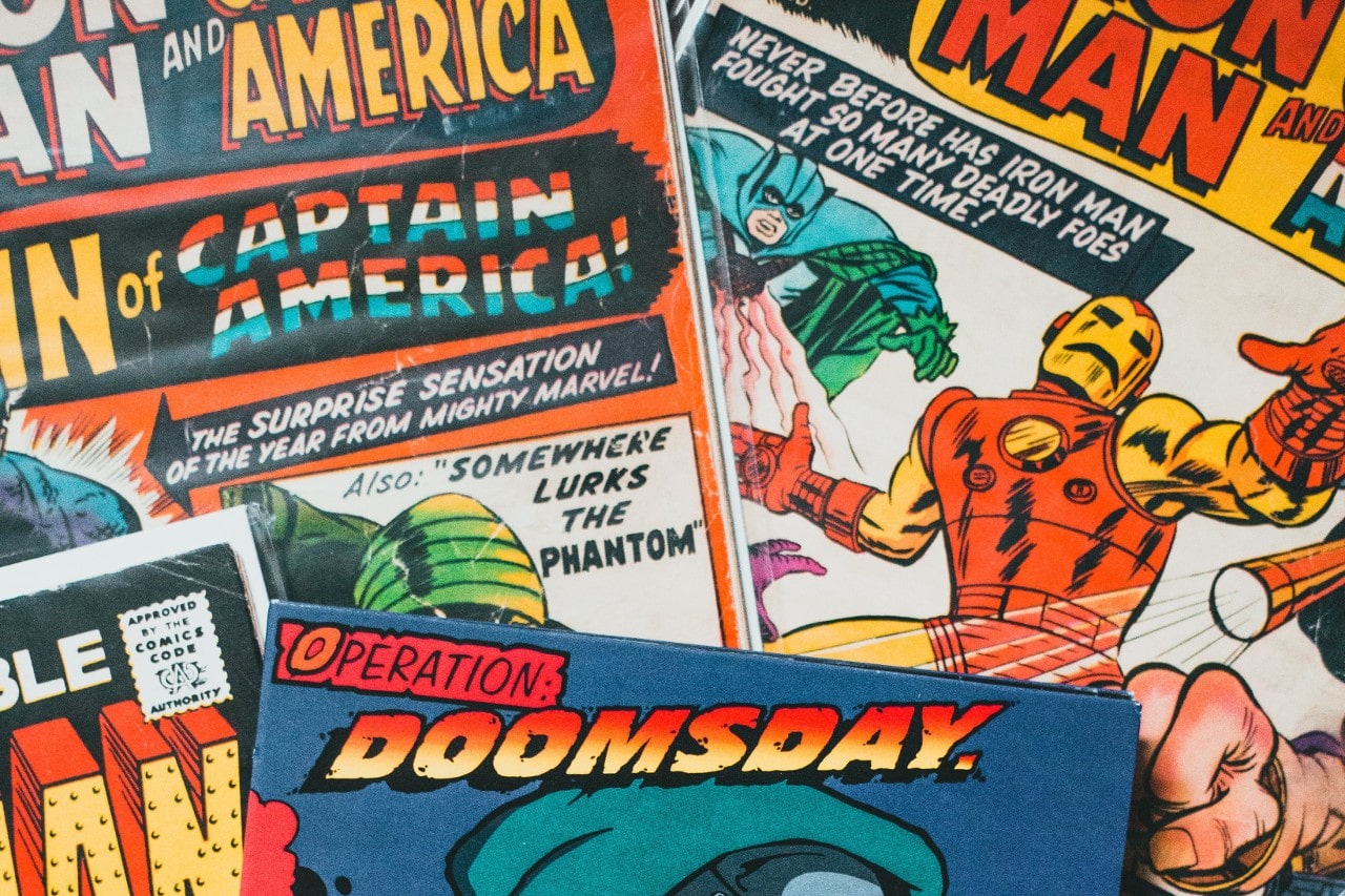 close up image of overlapping Marvel comic books featuring heroes like Iron Man and Captain America