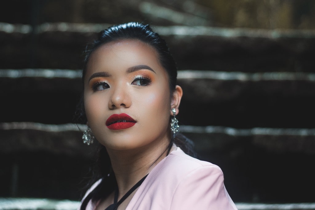 A woman wearing diamond drop earrings walks down the stairs at night. A woman wearing diamond drop earrings walks down the stairs at night.