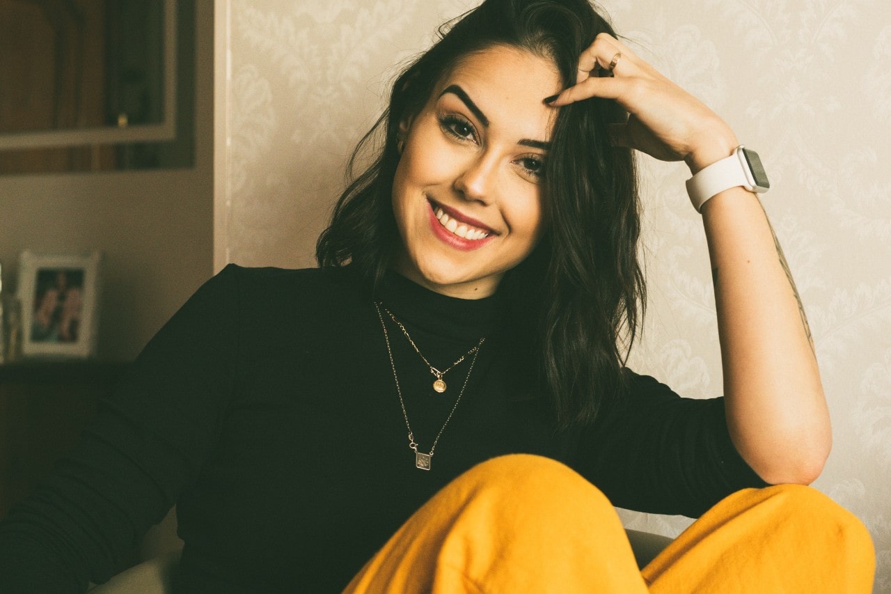 smiling lady wearing necklaces, a watch, and stylish clothes smiling lady wearing necklaces, a watch, and stylish clothes