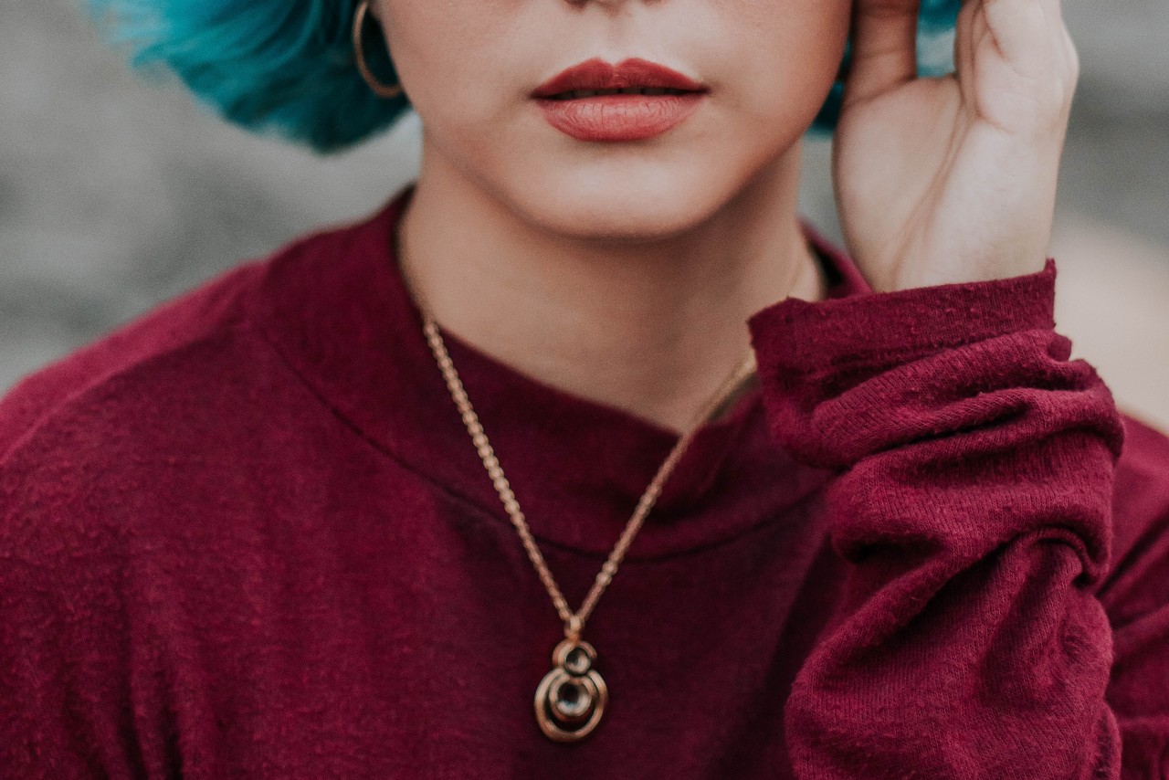 lady wearing a red sweater and rose gold necklace lady wearing a red sweater and rose gold necklace