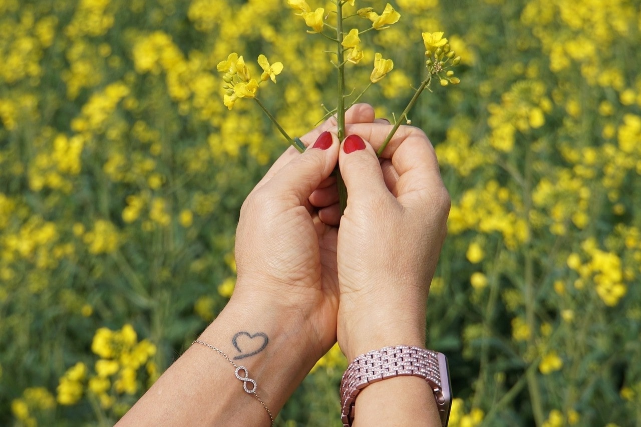 A lady’s hands holding flowers and wearing a watch and bracelet