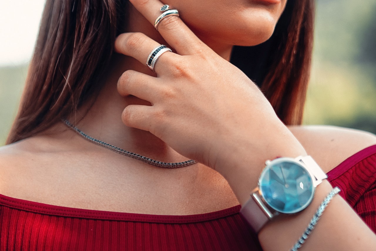 A woman wearing a blue watch  and silver jewelry