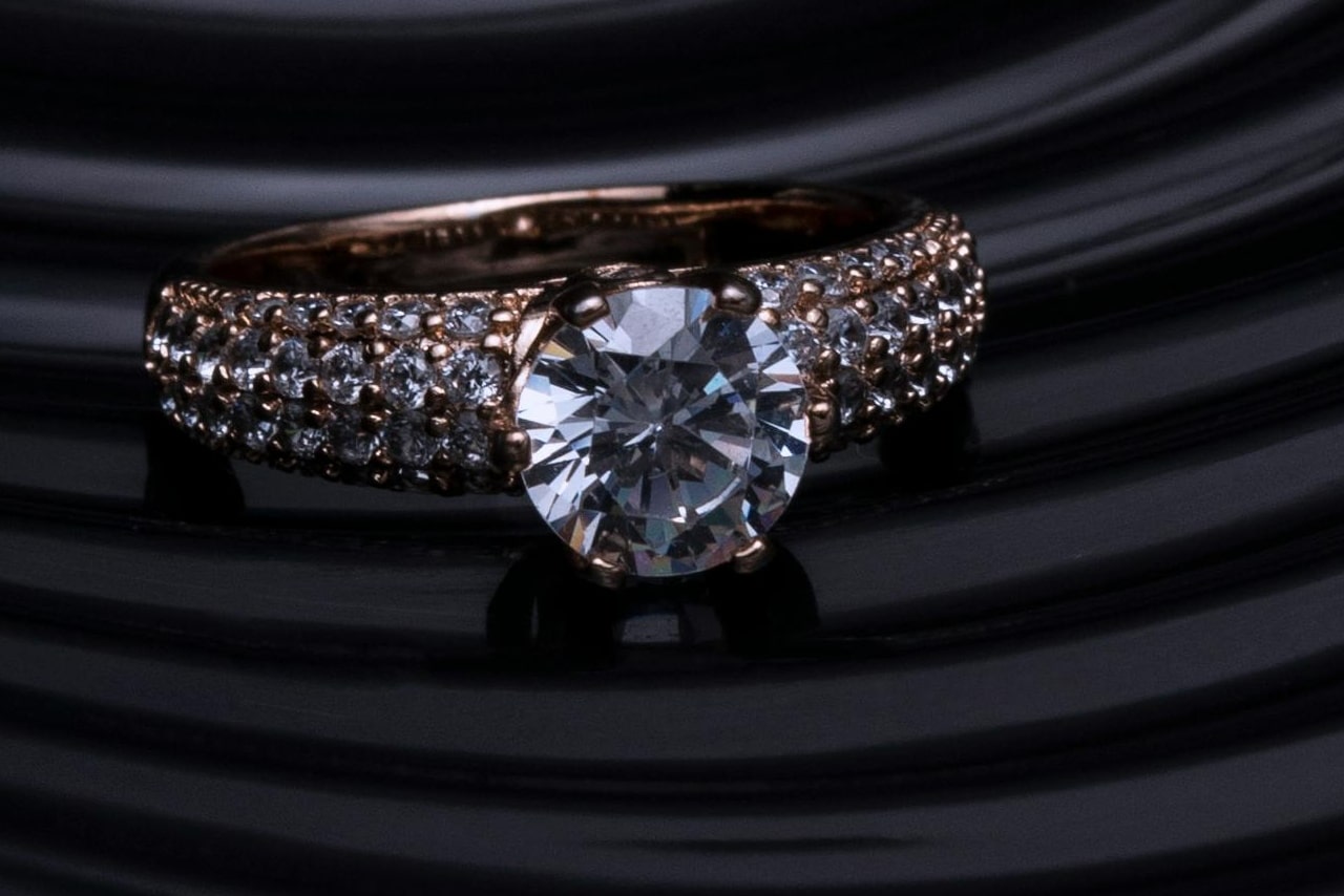 a rose gold engagement ring with pave set side stones