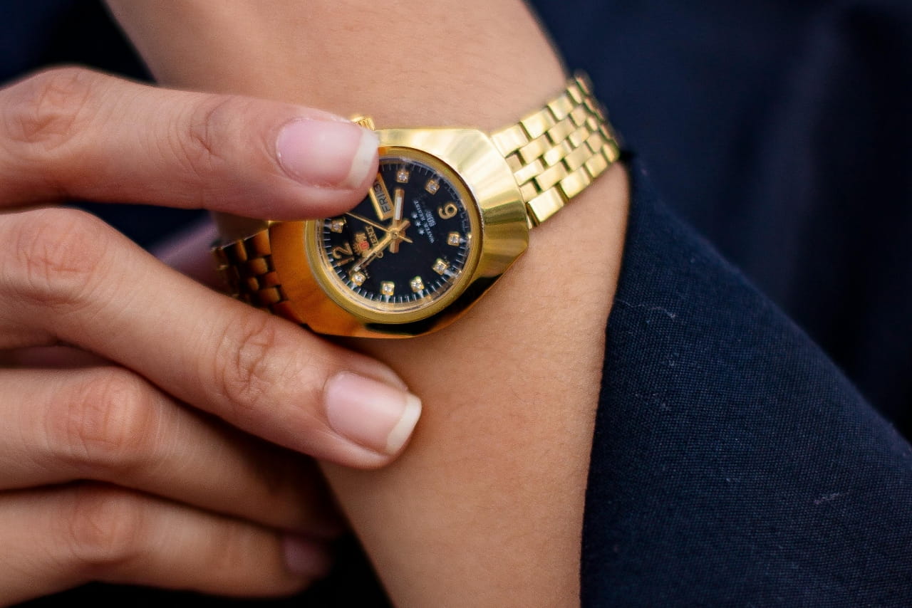 A hand holding a wrist wearing watch