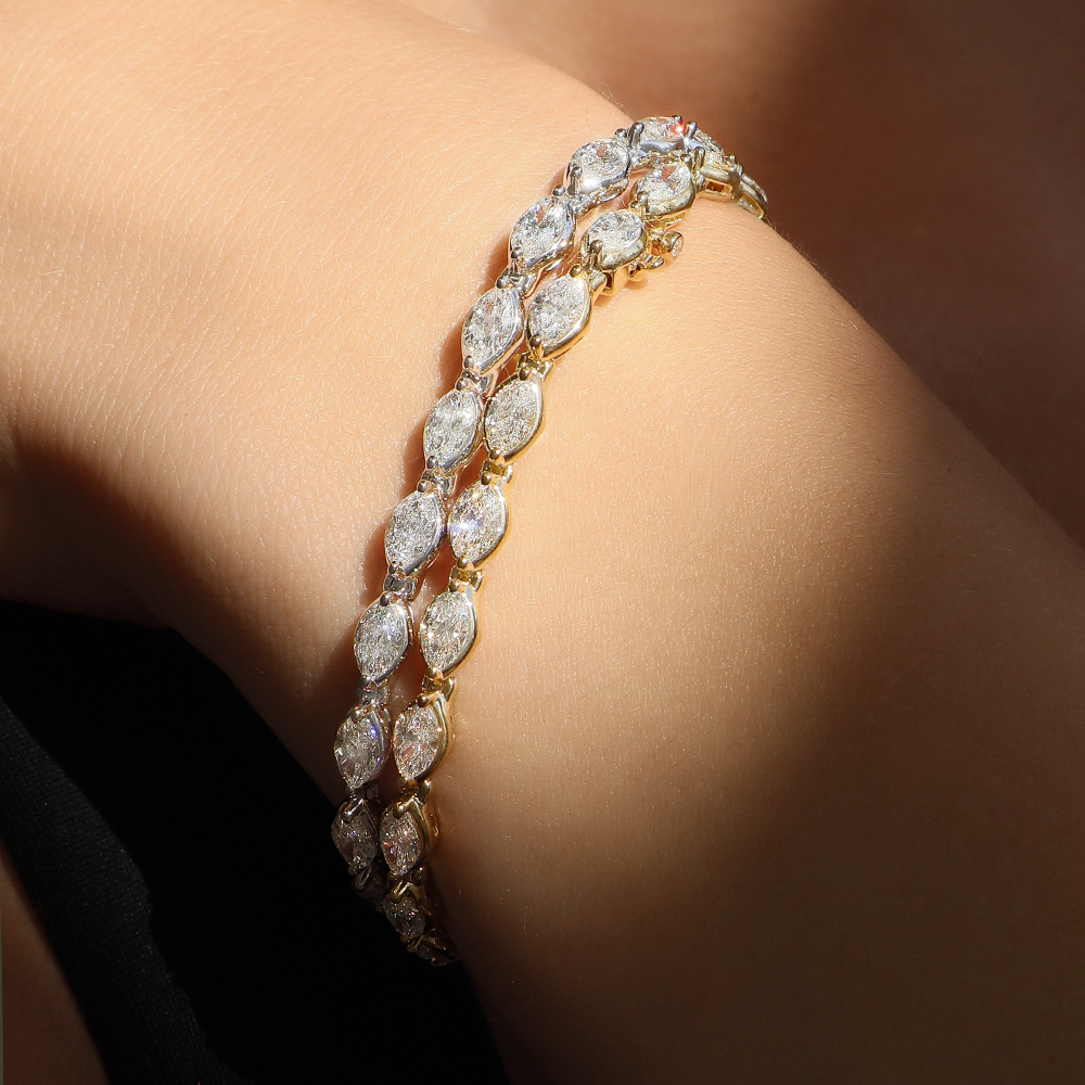 a white gold tennis bracelet featuring a line of round cut diamonds